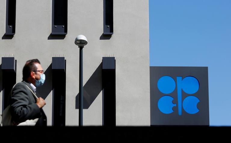 FILE PHOTO: A person passes the logo of the Organization of the Petroleoum Exporting Countries (OPEC) in front of OPEC's headquarters in Vienna, Austria April 9, 2020.  REUTERS/Leonhard Foeger/File Photo-NARCH/NARCH30