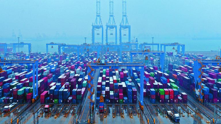 FILE PHOTO - Containers and trucks are seen on a snowy day at an automated container terminal in Qingdao port