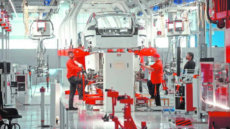 FILE PHOTO: Tesla workers examine a Model S used for training and tool calibration at the company