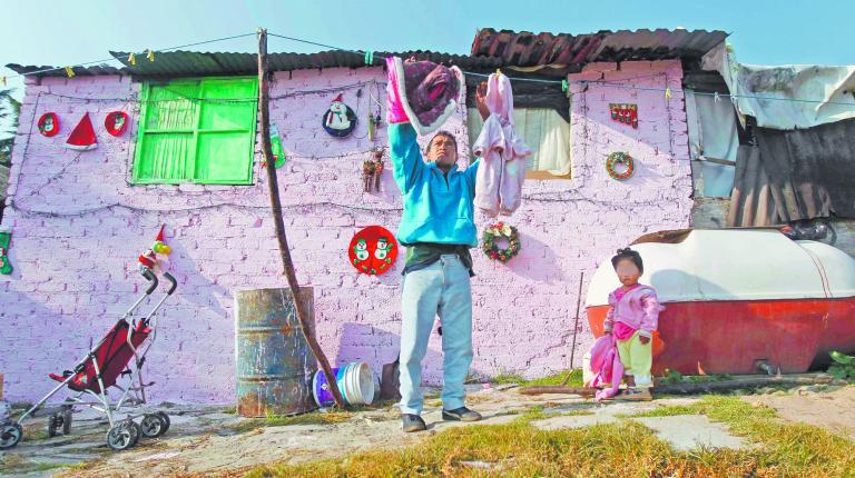 A man hangs up clothes to dry in a low-income neighborhood in Mexico City