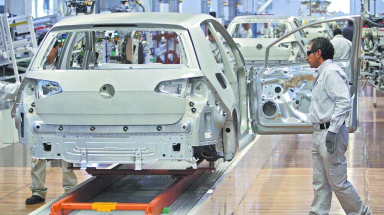 Workers work on the assembly line of the new Golf 7 at the Volkswagen plant in Puebla