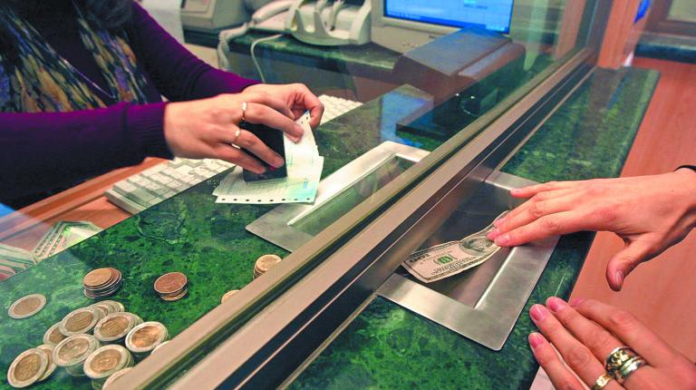 SANTIAGO, CHILE:  A civilian buys dollar at a currency exchange house in Santiago, Chile, 21 June 2002. Una persona compra dolares en una casa de cambio en Santiago, Chile el 21 de junio de 2002. El peso chileno experimento hoy una fuerte caida ante en dolar cerrando a 697,50 pesos chilenos por dolar al finalizar las operaciones bancarias, la caida estaria atribuida a la inquietud del mercado en brasil y la devaluacion de su moneda.             AFP PHOTO/Victor ROJAS (Photo credit should read VICTOR ROJAS/AFP/Getty Images)-Not Released (NR) This image is only available in Getty Images offices in the United Kingdom, United States, Germany (Austria, Switzerland via Germany) and Australia.