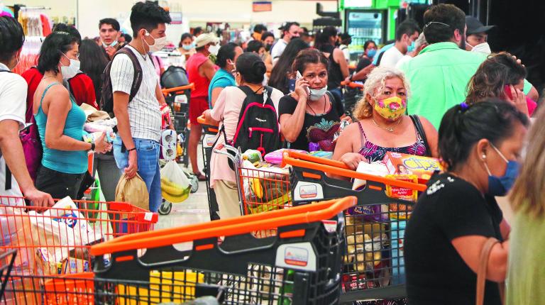 People queue to pay for goods at a supermarket, in preparation for the arrival of Hurricane Delta, in Cancun, Mexico October 6, 2020. REUTERS/Jorge Delgado