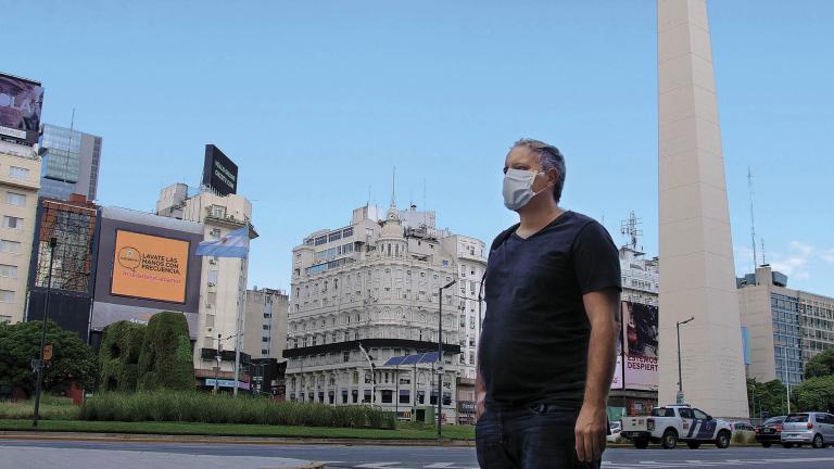 Buenos Aires, Argentina 03/19/2020 Man In Buenos Aires, Argentina Loneliness Near Argentine Obelisk With Face Mask Chinstrap 9 De Julio Avenue Trying Avoid Corona Virus COVID 19