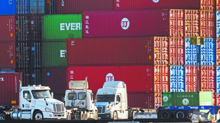 FILE PHOTO: Trucks arrive to pick up containers at the Port of Los Angeles in Los Angeles, California