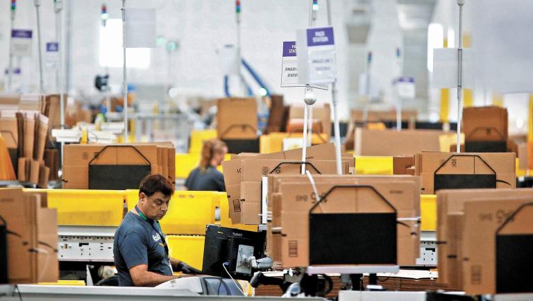 FILE PHOTO: Employees work at packing stations on the main floor at the Amazon fulfillment center in Kent, Washington, U.S., October 24, 2018.  REUTERS/Lindsey Wasson/File Photo                  GLOBAL BUSINESS WEEK AHEAD-NARCH/NARCH30