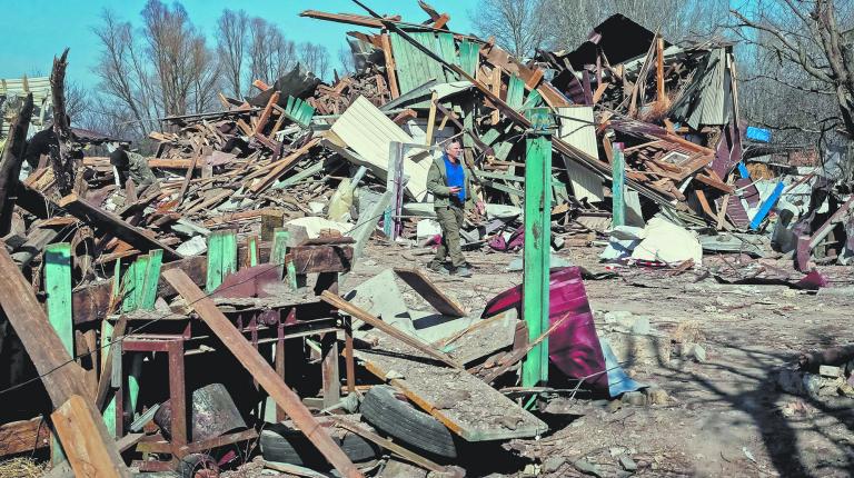 Local resident walks in a destroyed a village on the front line in the east Kyiv region