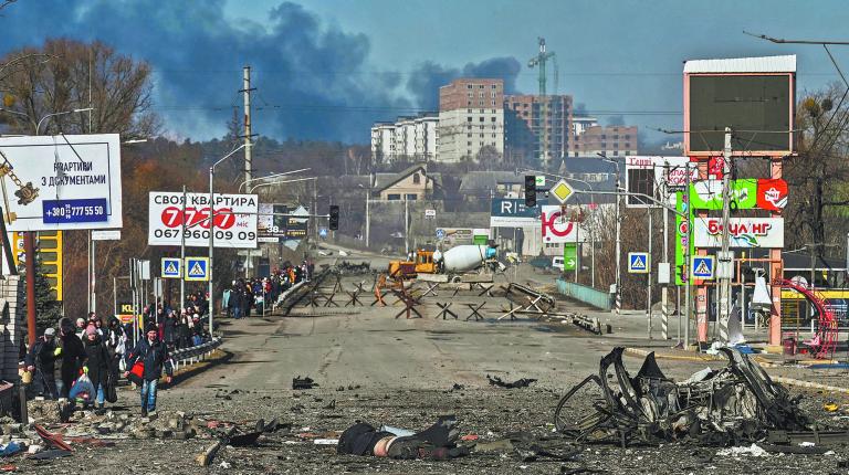 Residents evacuate the city of Irpin, north of Kyiv, on March 10, 2022. - Russian forces on March 10, 2022 rolled their armoured vehicles up to the northeastern edge of Kyiv, edging closer in their attempts to encircle the Ukrainian capital. Kyiv's northwest suburbs such as Irpin and Bucha have been enduring shellfire and bombardments for more than a week, prompting a mass evacuation effort. (Photo by Aris Messinis / AFP)