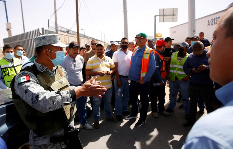 Un miembro de la Guardia Nacional habla con camioneros mexicanos mientras bloquean un puente internacional para protestar contra las inspecciones de camiones impuestas por el gobernador de Texas, Greg Abbott. Foto: Reuters.