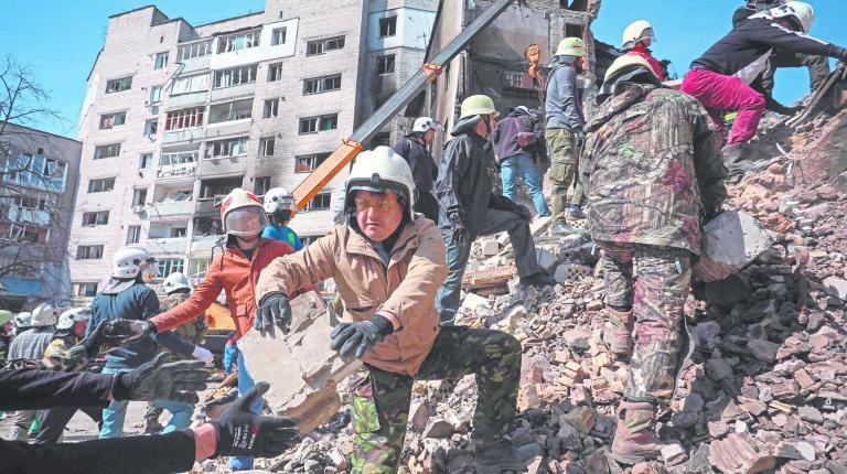 Volunteers help rescuers to remove rumbles of a damaged building in the town of Borodianka, northwest of Kyiv, on April 7, 2022, during Russia's military invasion launched on Ukraine. (Photo by Aleksey Filippov / AFP)