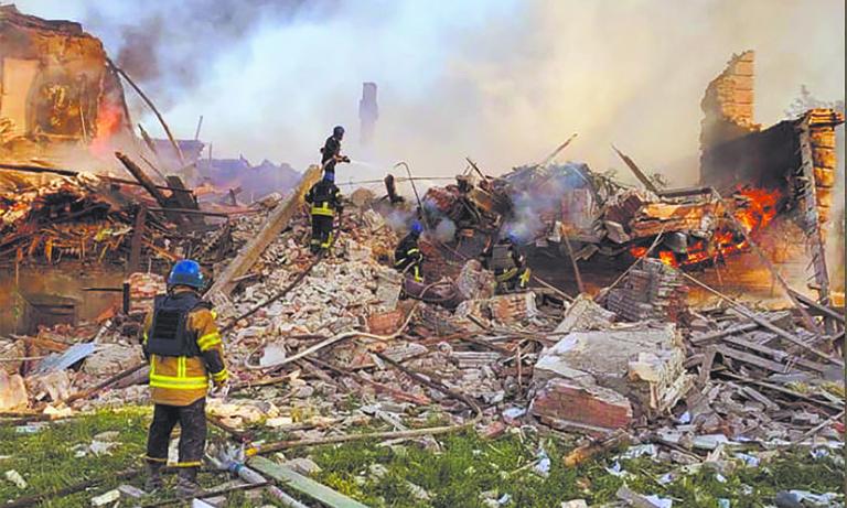 This handout photograph released by Ukrainian State Emergency Service on May, 8, 2022, show Ukrainian firefighters putting out a fire after Russian missiles hit a school in eastern Ukraine's Lugansk region on May, 7, 2022. - Sixty civilians died in the bombing of a school in eastern Ukraine's Lugansk region this weekend, President Volodymyr Zelensky said on May, 8, 2022. 