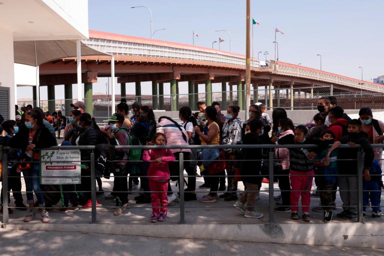 Asylum-seeking migrants wait outside the office of the Center for Integral Attention to Migrants (CAIM) to request information about their asylum in the United States, in Ciudad Juarez