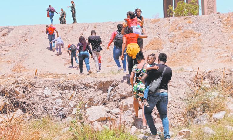 Asylum-seeking migrants cross the Rio Bravo river in Ciudad Juarez