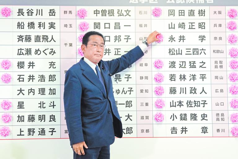 El primer ministro Fumio Kishida coloca una rosa en el nombre de un candidato de su partido que ganó ayer en las elecciones para senadores. Foto: Reuters