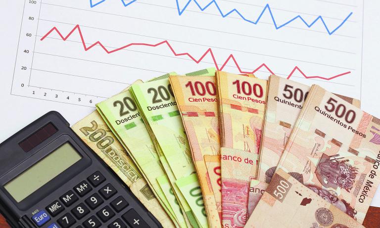 Mexican peso banknotes and chart data analysis on stock market or sales. Business concept image. Stack of Mexican pesos and calculator.