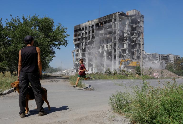 Workers demolish a multi-storey apartment block in Mariupol