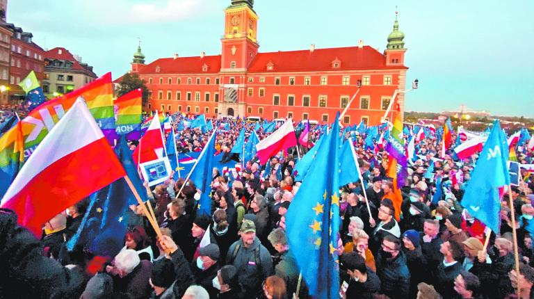 People carry flags and signs, as they take part in a rally in support of Poland's membership in the European Union after the country's Constitutional Tribunal ruled on the primacy of the constitution over EU law, undermining a key tenet of European integration, in Warsaw, Poland, October 10, 2021. REUTERS/Kacper Pempel