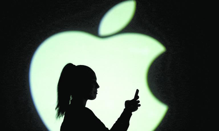 FILE PHOTO: Silhouette of mobile user is seen next to a screen projection of Apple logo in this picture illustration taken March 28, 2018.  REUTERS/Dado Ruvic/Illustration/File Photo-NARCH/NARCH30 NARCH/NARCH30