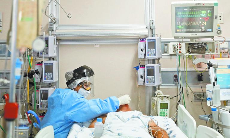 SENSITIVE MATERIAL. THIS IMAGE MAY OFFEND OR DISTURB    A medical worker in protective suit treats a patient suffering from the coronavirus disease (COVID-19) in an intensive care unit at Hospital Juarez de Mexico in Mexico City, Mexico October 29, 2020. REUTERS/Carlos Jasso-SMOUT