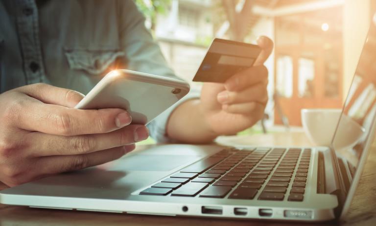 Online payment,Man's hands holding smartphone  and using credit card for online shopping.