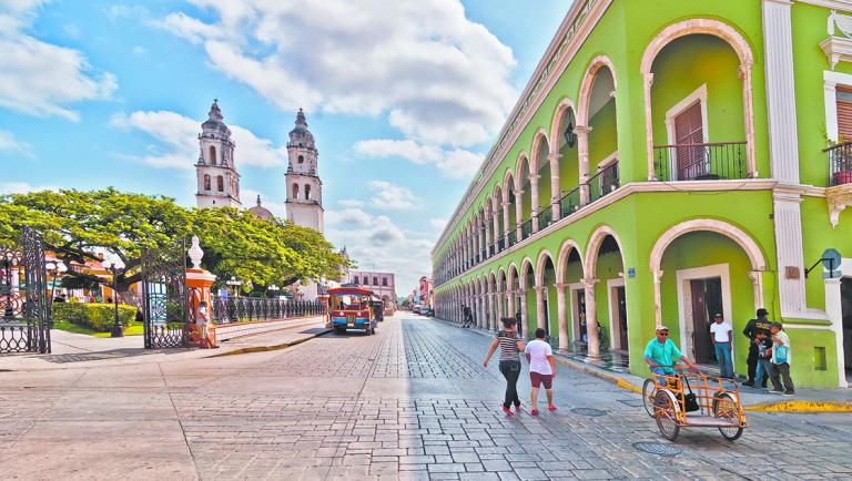 CAMPECHE, MEXICO - APRIL 19, 2014: locals and tourists in main square with Cathedral in Campeche, Mexico. The city was founded in 1540 by Spanish conquistadores atop pre-existing Maya city of Canpech