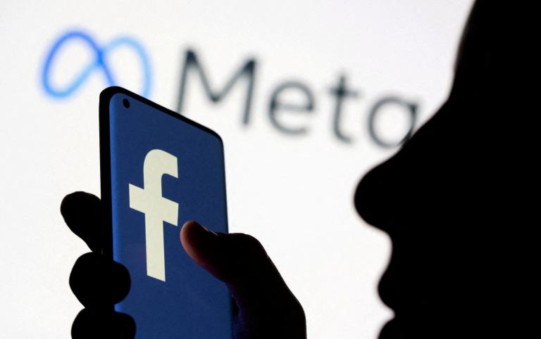 FILE PHOTO: A woman holds smartphone with Facebook logo in front of a displayed Facebook's new rebrand logo Meta in this illustration picture taken October 28, 2021. REUTERS/Dado Ruvic/Illustration/File Photo-NARCH/NARCH30 NARCH/NARCH30 NARCH/NARCH30 NARCH/NARCH30 NARCH/NARCH30