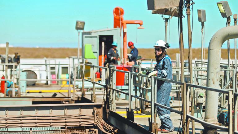 FILE PHOTO: A worker looks on over a platform in a drilling rig at Vaca Muerta shale oil and gas drilling, in the Patagonian province of Neuquen