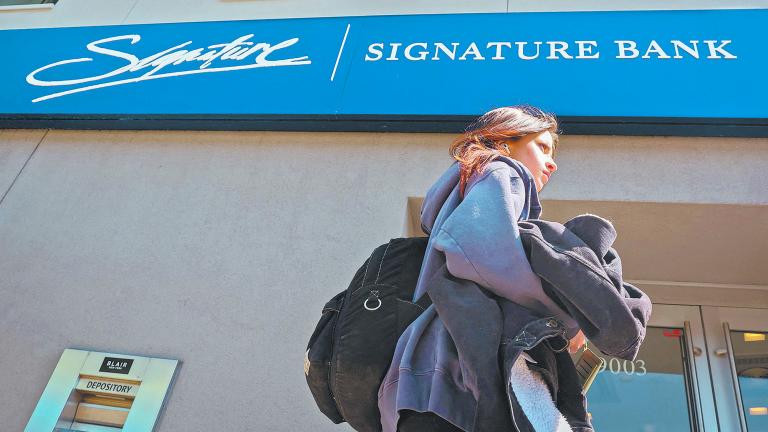 A woman walks past a Signature Bank location in Brooklyn, New York