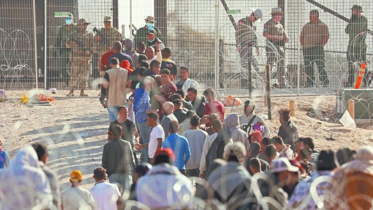 Migrants stand near the border wall after having crossed the U.S.-Mexico border to turn themselves in to U.S. Border Patrol agents, after the lifting of COVID-19 era Title 42 restrictions that have blocked migrants at the border from seeking asylum since 2020, as seen from Ciudad Juarez, Mexico May 12, 2023. REUTERS/Jose Luis Gonzalez