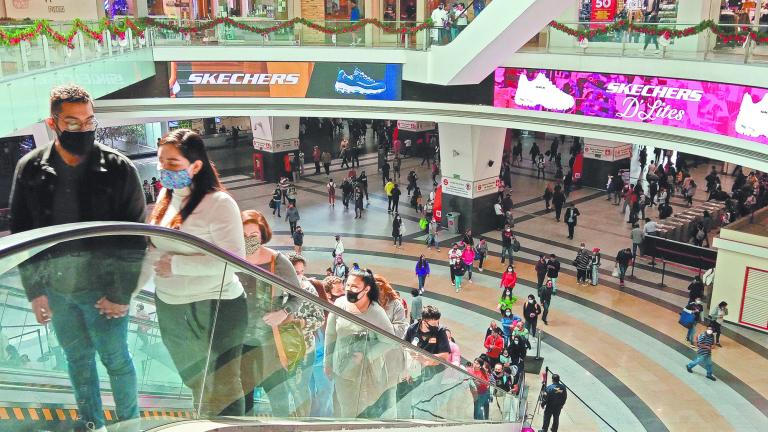 Decenas de personas estran al centro comercial.