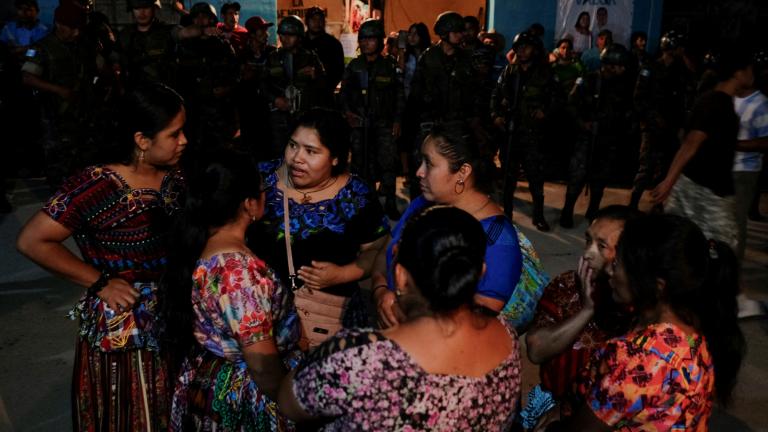 Mujeres frente a un centro de votación custodiadas por miembros del ejército y la policía, después de que habitantes del pueblo intentaron ingresar al centro durante el conteo de votos, en el día de la primera vuelta de las elecciones presidenciales de Guatemala en Chinautla, Guatemala. Foto: Reuters