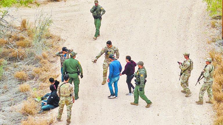 FILE PHOTO: Border patrol agents and Texas Army National Guard soldiers detain migrants, who were hiding in thick brush, after they crossed the Rio Grande river into the United States from Mexico in La Joya, Texas, U.S., March 17, 2023.  REUTERS/Adrees Latif/File Photo-NARCH/NARCH30