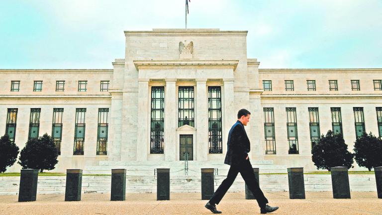 FILE PHOTO: A man walks past the Federal Reserve in Washington