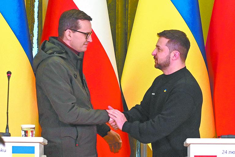 El presidente de Ucrania Volodímir Zelenski saluda al primer ministro de Polonia Mateusz Morawiecki en imagen del 24 de febrero en Kyiv. Foto: Reuters