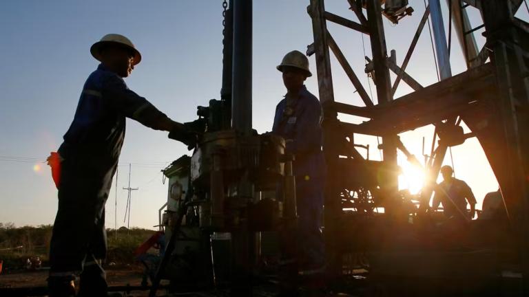 Trabajadores petroleros estatales perforan un pozo en un campo petrolero. Foto: Shutterstock.