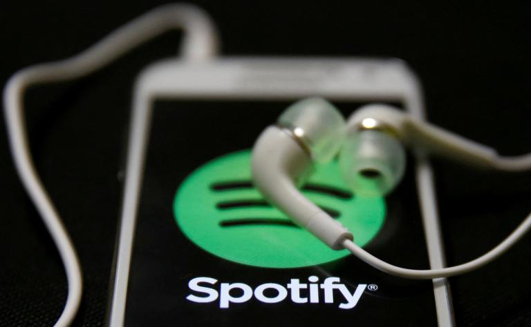 FILE PHOTO: Earphones are seen on top of a smart phone with a Spotify logo on it, in Zenica