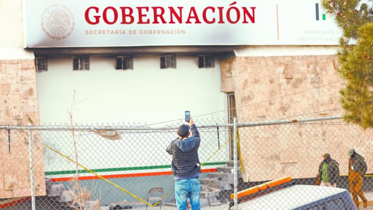 A migrant records a video with a phone outside the National Migration Institute (INM) building, after a fire broke out late on Monday at a migrant holding center, in Ciudad Juarez, Mexico, March 28, 2023. REUTERS/Jose Luis Gonzalez