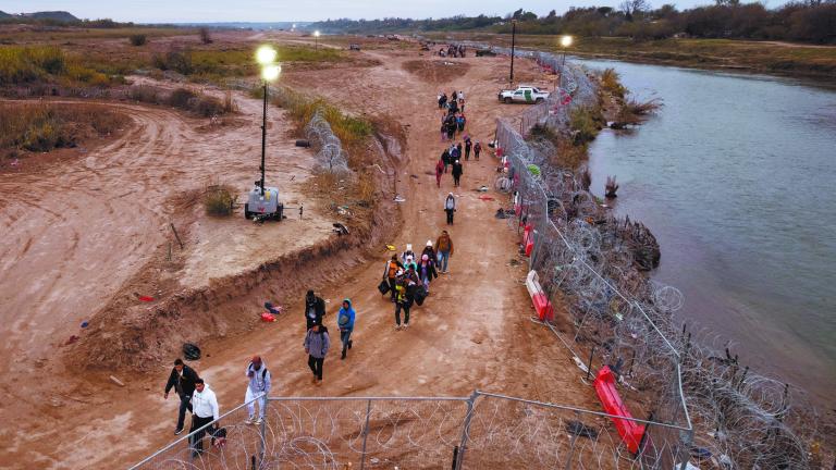 Migrants cross from Mexico into Eagle Pass, Texas