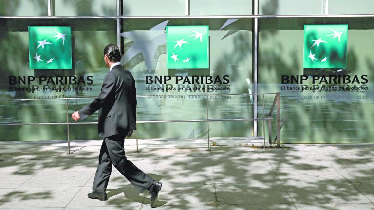 A man walks past a BNP Paribas bank office in Madrid