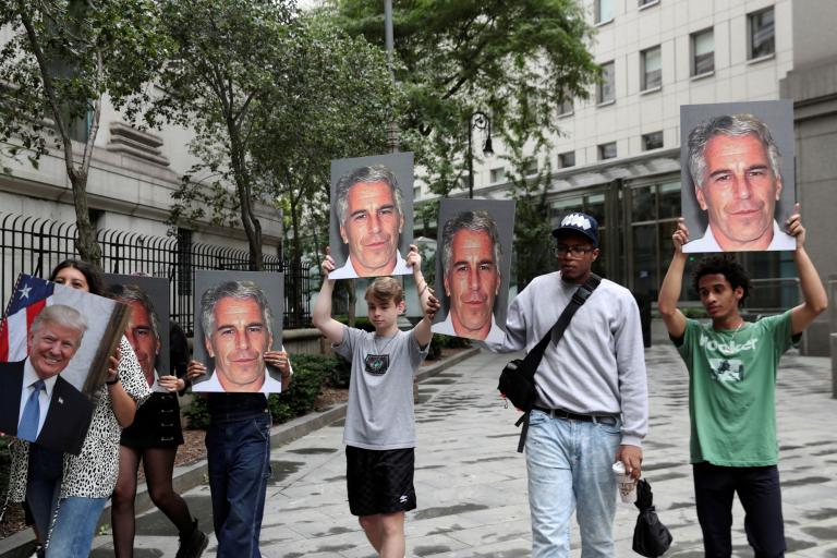 FILE PHOTO: Demonstrators hold photos aloft protesting Jeffrey Epstein in New York