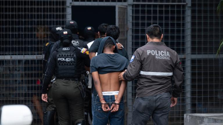 Agentes de la Policía Nacional Ecuatoriana escoltan a varios presuntos miembros de la banda criminal "Los Lobos" capturados durante una operación policial después de que atacaron un puesto de policía en Guayaquil, Ecuador, el 14 de enero de 2024. Foto: AFP