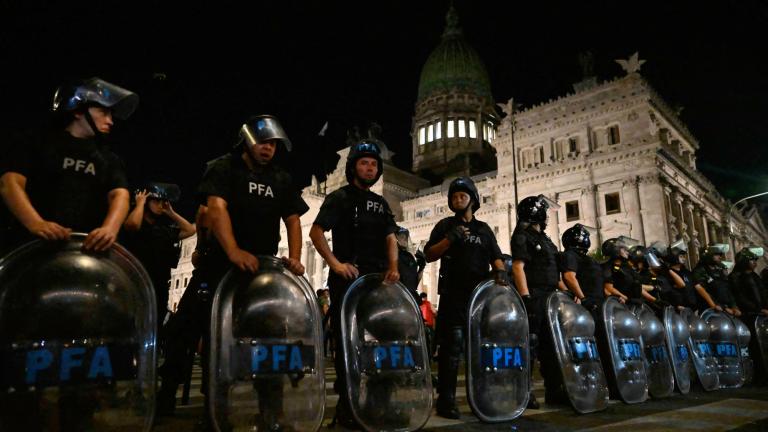 Miembros de la policía montan guardia mientras personas realizan una manifestación contra el "proyecto de ley ómnibus" fuera del Congreso, mientras los congresistas llevan a cabo el debate del proyecto de ley, en Buenos Aires el 31 de enero de 2024. Foto: AFP