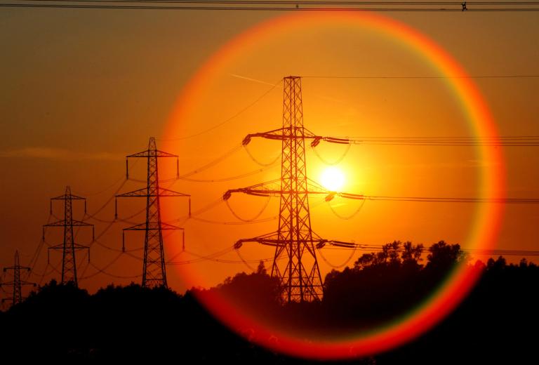 FILE PHOTO: The sun sets behind pylons in central England