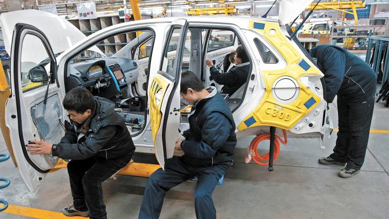 Employees work on an assembly line producing electronic cars at a factory of Beijing Electric Vehicle, funded by BAIC Group, in Beijing, China, January 18, 2016.REUTERS/Kim Kyung-Hoon