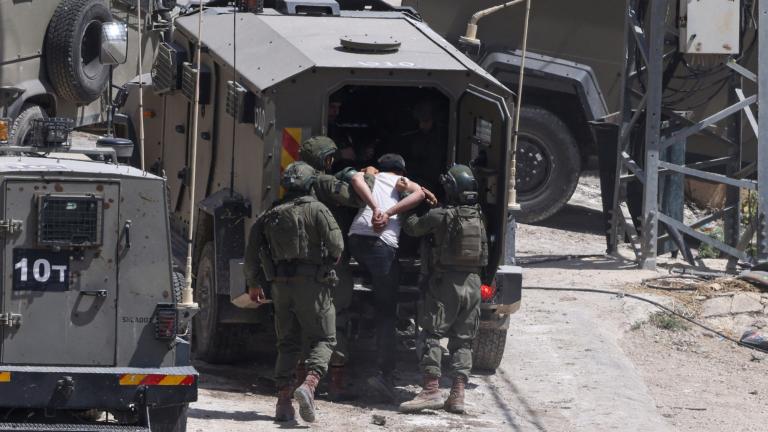 Soldados israelíes detienen a un palestino durante una redada en la ciudad ocupada de Deir al-Ghusun, en Cisjordania. Foto: AFP.