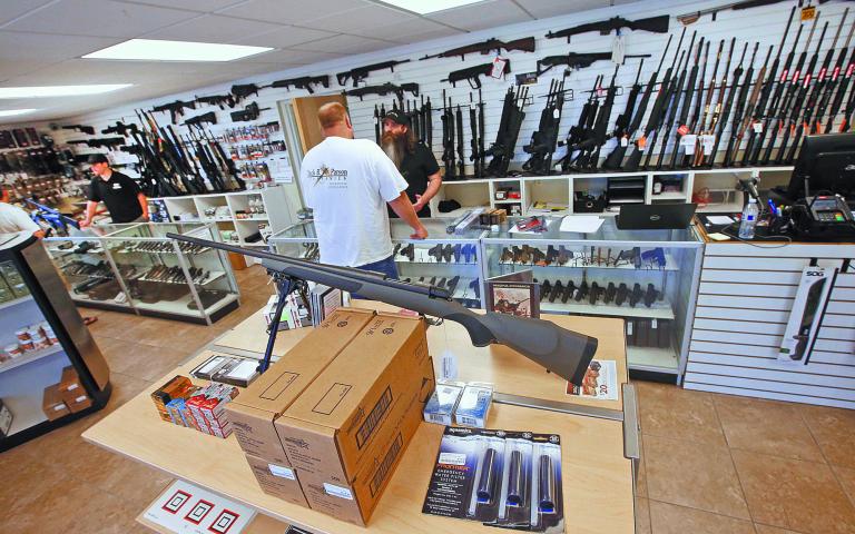 Prospective buyers look at guns at the "Ready Gunner" gun store In Provo