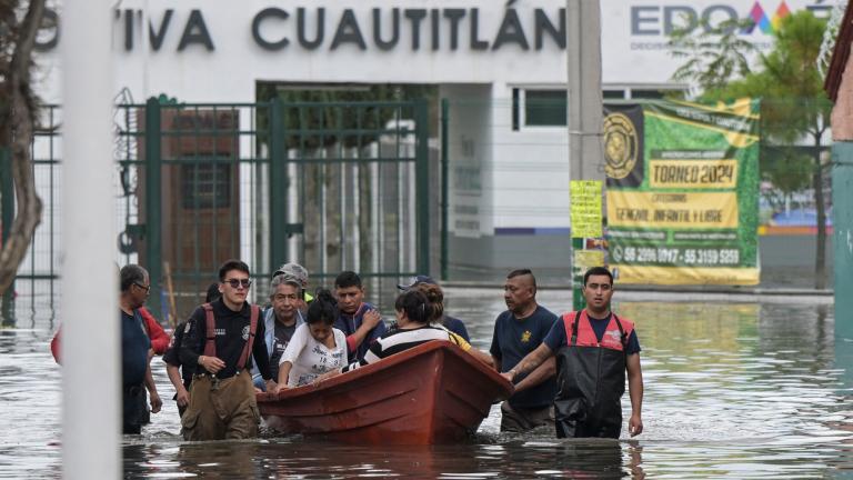 Bomberos y personal de Protección Civil rescataron a decenas de familias afectadas por la obstrucción de coladeras. Foto: AFP