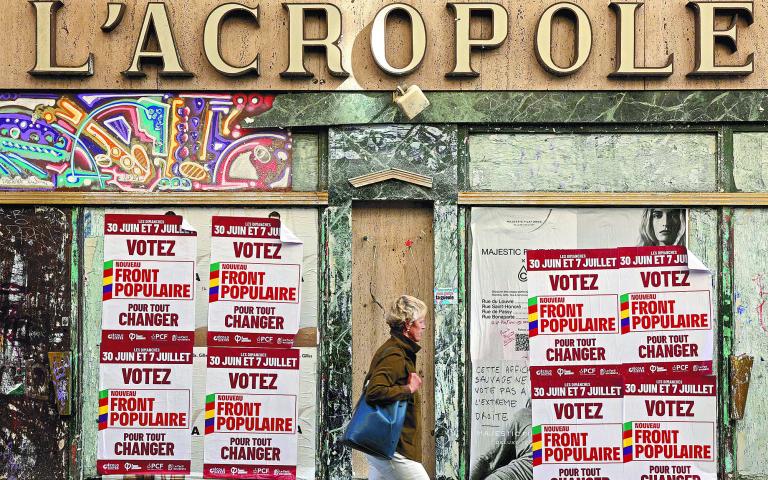 Un peatón pasa junto a carteles publicitarios del Nuevo Frente Popular, ayer en París. Foto: AFP