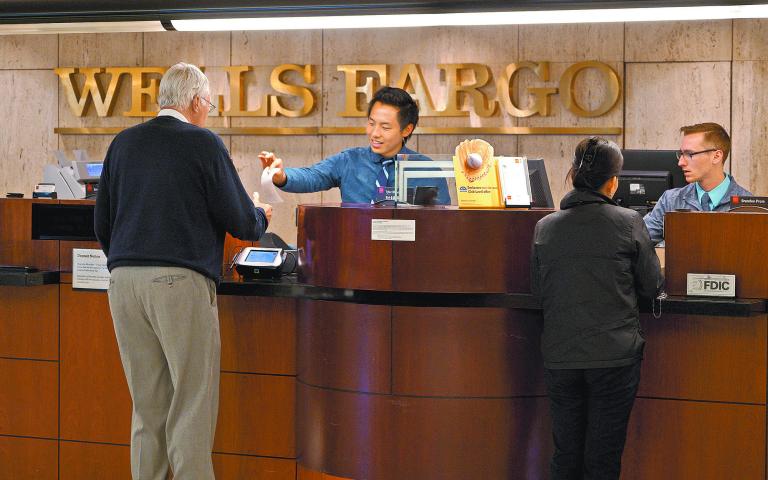 FILE PHOTO: Tellers serve customers at the Wells Fargo & Co. bank in downtown Denver