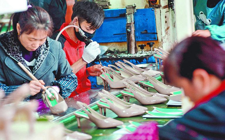 This photo taken on March 25, 2018 shows Chinese employees producing shoes for export at a factory in Shangrao, in China's central Jiangxi province. (Photo by AFP) / China OUT / CHINA OUT-China OUT / CHINA OUT